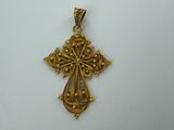 a gold cross pendant on a white background