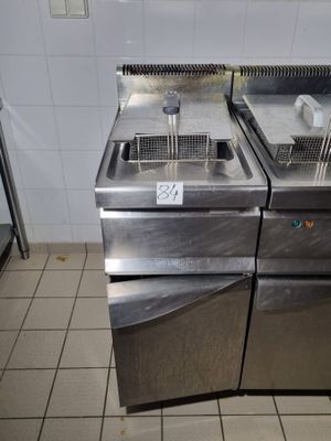 deux friteuses posées sur un plan de travail en inox