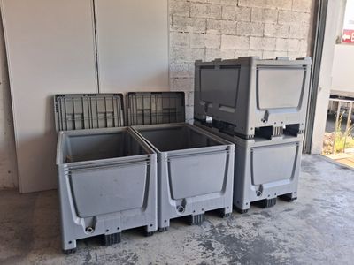 three plastic containers sitting next to each other in a garage