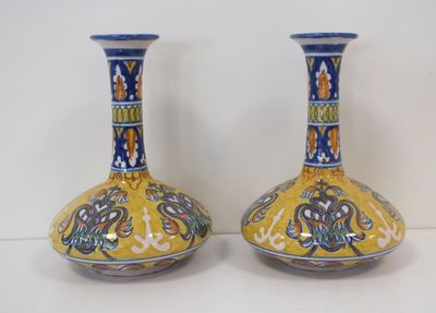 pair of yellow and blue vases sitting on a white surface
