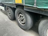 un camion sur le flanc duquel est fixée une bâche verte