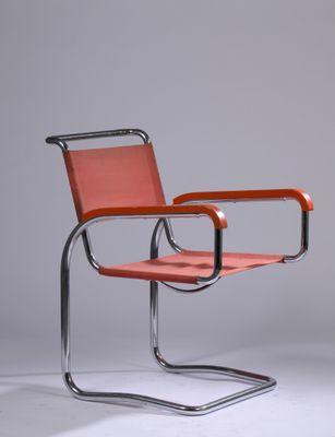 une chaise orange avec une structure en métal et une assise en cuir