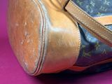 a brown and black bag on a pink surface
