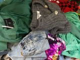 a pile of clothes that is sitting on a bed
