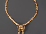 a gold necklace on a gray background