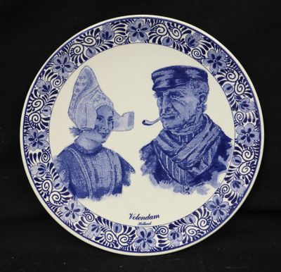 a blue and white plate with a drawing of a man and a woman