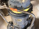 un aspirateur posé sur le sol du garage