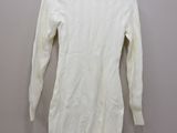 a white sweater hanging on a hanger on a wall