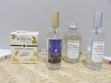 three bottles of perfume and a box of soap on a tray