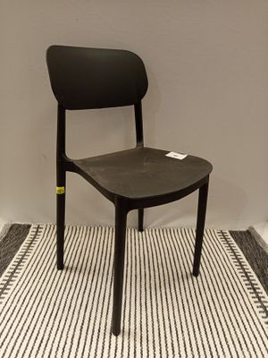 a black chair sitting on a striped rug in a room