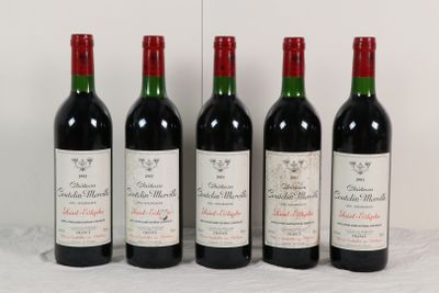 quatre bouteilles de vin sont alignées sur une table