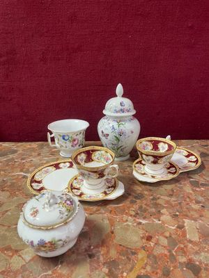 a table with a tea set on it with a red background