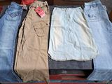 three pairs of jeans sitting in a suitcase on the floor