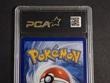 the pokemon card is in a plastic holder on a black surface