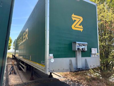 un semi-remorque vert garé sur le bord de la route