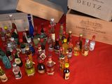 many bottles of alcohol sitting on a table with a red table cloth