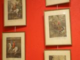 des tableaux accrochés au mur d'une pièce aux murs rouges