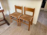 two wooden chairs sitting next to each other on the floor