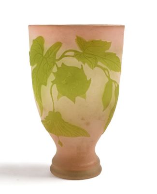 un vase rose orné de feuilles vertes sur fond blanc