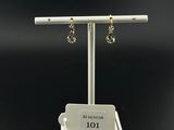 a white display stand with two pairs of earrings on it