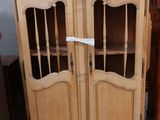 un meuble en bois avec des portes en verre dans une pièce