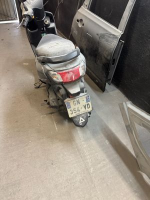 un scooter garé à côté d'une voiture dans un garage
