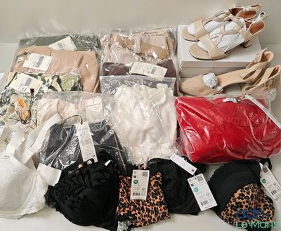 de nombreux modèles différents de vêtements et de chaussures pour femmes sont exposés sur la table