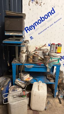 une table bleue sur laquelle sont posés de nombreux objets, devant un mur