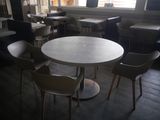 tables and chairs in a restaurant with a large window in the background