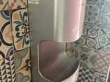 a pink and silver hand dryer on a tiled wall