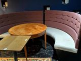 une table ronde avec un plateau en bois dans une pièce aux murs bleus
