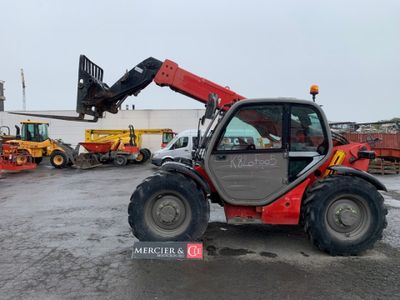 une photo d'un tracteur rouge équipé d'une grue à l'arrière