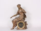 a statue of a woman sitting on top of a clock