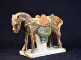 a figurine of a horse with a saddle on its back