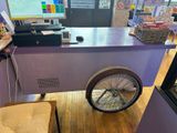 a purple cart with a bike on it in a store