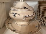 several plates and bowls are stacked on a shelf in a kitchen