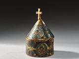 a close up of a gold and blue box with a cross on top