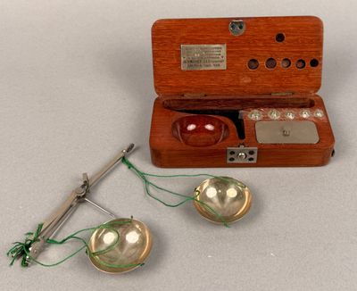 a small wooden box with a sewing needle and a pair of buttons