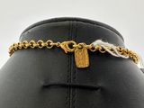 the chain has a gold plated tag on it and is attached to a mannequin