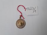une médaille d'or suspendue à un cordon rouge