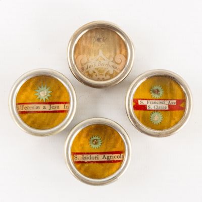 three tins with labels on them are sitting on a white surface