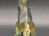 a glass figurine of a bear on a black surface