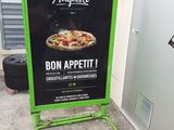 a sign for a pizza restaurant on the side of the street