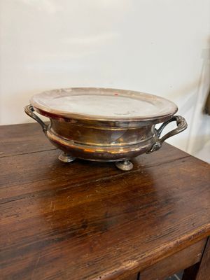 a silver bowl sitting on a wooden table