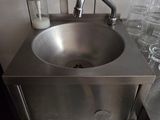 a stainless steel sink in the corner of a kitchen