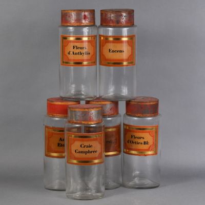 Plusieurs bocaux en verre portant des étiquettes orange sont empilés les uns sur les autres