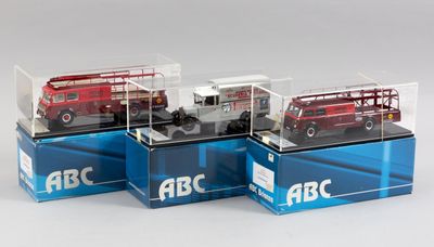 quatre modèles réduits de véhicules différents sont exposés dans des vitrines posées sur un socle blanc