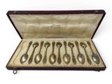 six spoons in a case on a white surface