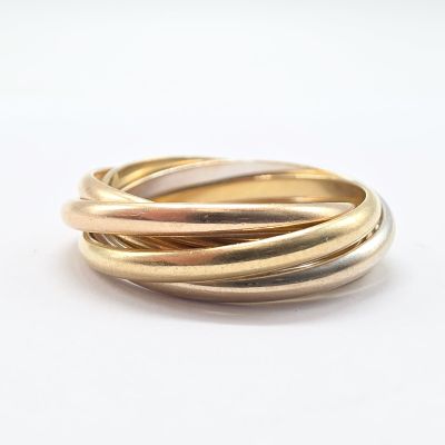 a close up of a gold and silver ring on a white surface