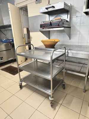 un chariot de cuisine en acier inoxydable muni d'un saladier sur le dessus